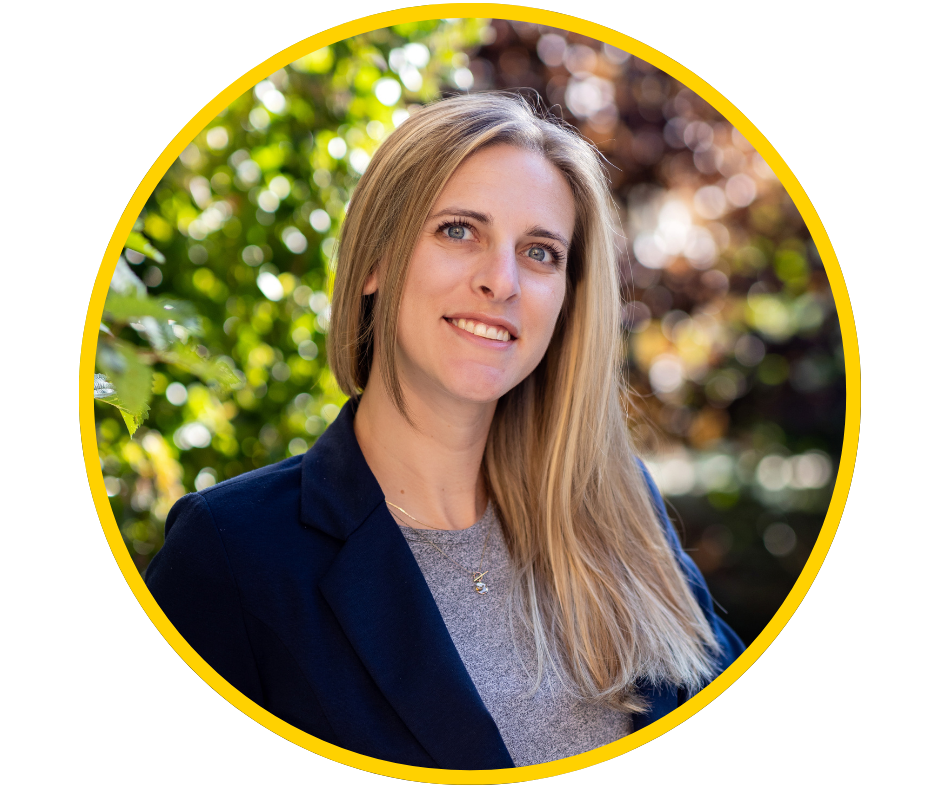 Stephanie, a young woman with light skin and long blonde hair, smiles wearing a black blazer.