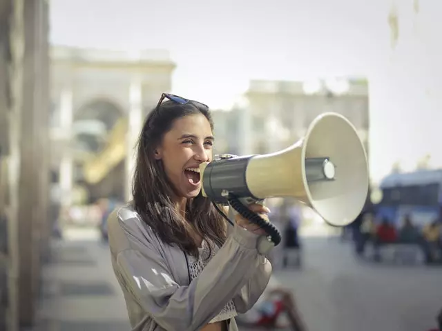 a smiling woman using a megaphone