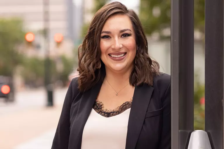 renee romero with long dark brown hair wearing a black blazer and white top